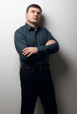 eller gri arka plan üzerinde koyu gömlek ve siyah pantolon giymiş, geçiş ile adam portresi