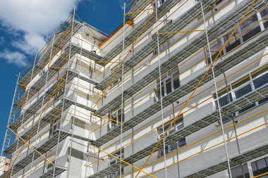 scaffolding near a new house, building exterior, construction and repair industry, white wall and window, yellow pipe clipart