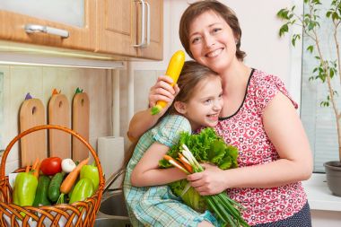 Anne ve kızı ile ev mutfak iç - sağlıklı gıda kavramı taze meyve ve sebze sepeti