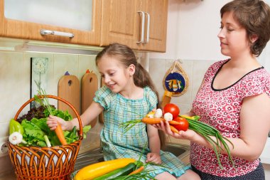 Anne ve kızı yemek. Sebze ve meyve mutfak iç sepet. Üst ve alt. Sağlıklı gıda kavramı