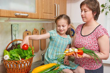Anne ve kızı yemek. Sebze ve meyve mutfak iç sepet. Üst ve alt. Sağlıklı gıda kavramı
