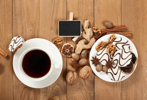Tazza di caffè e biscotti su sfondo di legno, spezie e decorazioni, bordo nero in miniatura per testo, vista dall'alto, stile retrò — Foto Stock