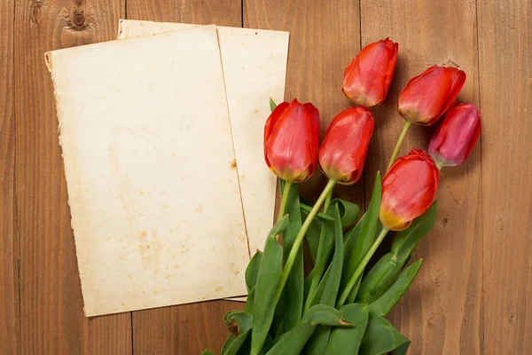 Tulipani sono su tavole di legno, vecchio foglio di carta bianca con posto per il testo - vacanza e concetto di saluto — Foto Stock