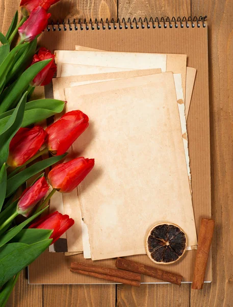 Tulipanes están en tableros de madera, hojas viejas de papel en blanco para texto, concepto de saludo en estilo retro —  Fotos de Stock