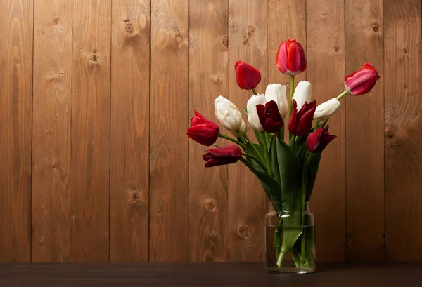 Bouquet di tulipani in vaso, fondo in legno — Foto Stock