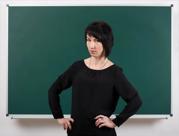 Girl teacher posing by chalk Board, learning concept, green background, Studio shot — Stock Photo, Image