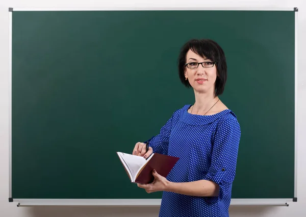 Lehrerin posiert mit Kreidetafel, Lernkonzept, grüner Hintergrund, Studioaufnahme — Stockfoto