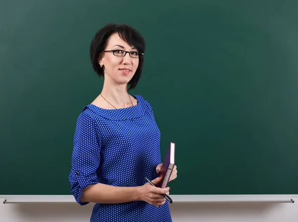 Vrouw leraar poseren door krijt Board, leren concept, de groene achtergrond, Studio-opname — Stockfoto