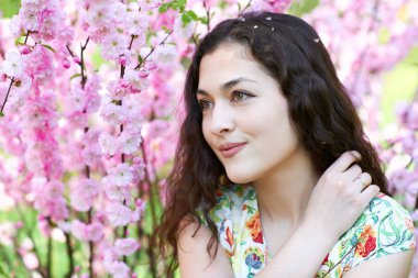 pembe çiçekler arka plan üzerinde genç güzel kız portresi, yüz yakın çekim