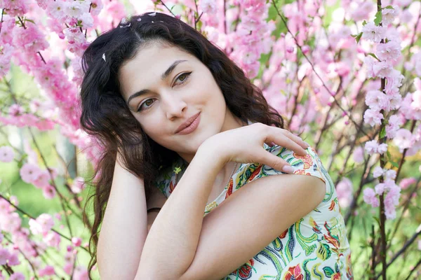 Portré, fiatal, gyönyörű lány rózsaszín virágokkal-háttérrel, arc közelről — Stock Fotó