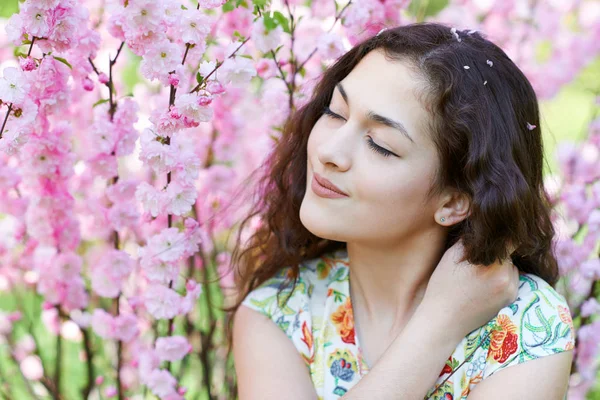 Portré, fiatal, gyönyörű lány rózsaszín virágokkal-háttérrel, arc közelről — Stock Fotó