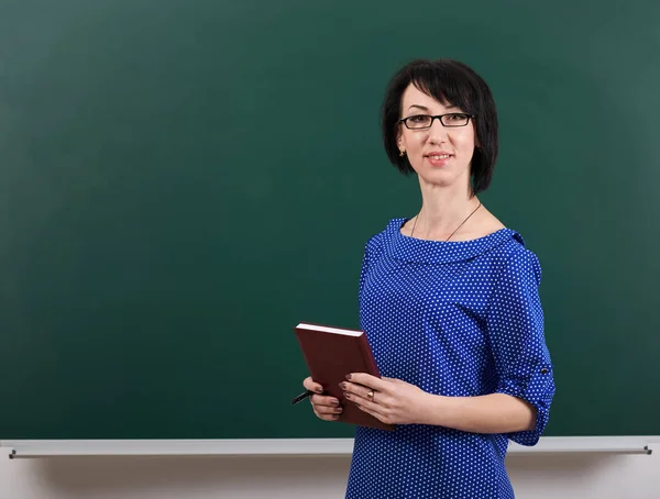 Lehrerin posiert mit Kreidetafel, Lernkonzept, grüner Hintergrund, Studioaufnahme — Stockfoto