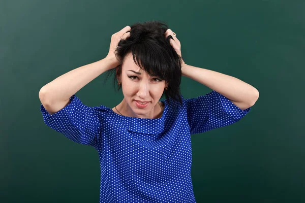 Enseignante dans le stress posant par tableau de craie, déchire ses cheveux, concept d'apprentissage, fond vert, plan studio — Photo