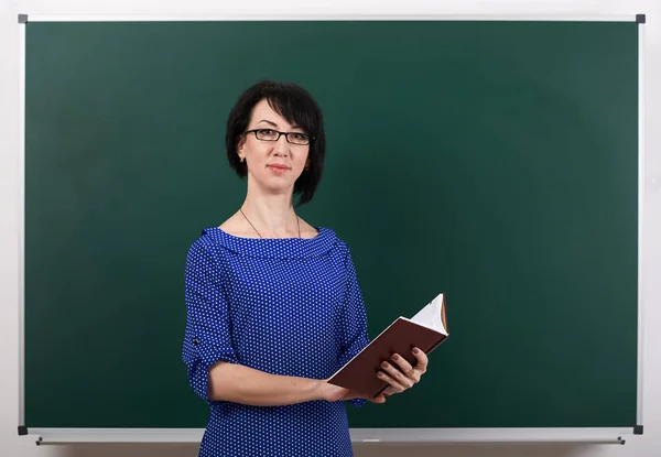 Lehrerin posiert mit Kreidetafel, Lernkonzept, grüner Hintergrund, Studioaufnahme — Stockfoto
