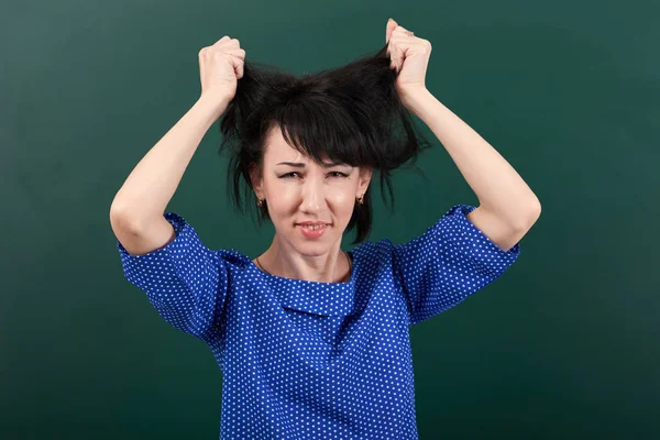 Femme professeur dans le stress posant sur fond de tableau de craie, toucher ses cheveux — Photo