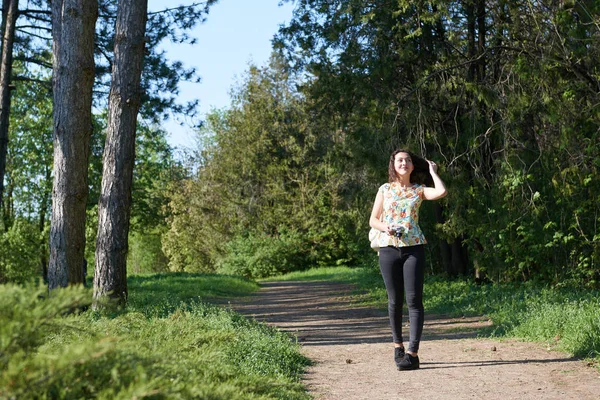 Niña caminando en el bosque de primavera con la cámara y tomando fotos —  Fotos de Stock