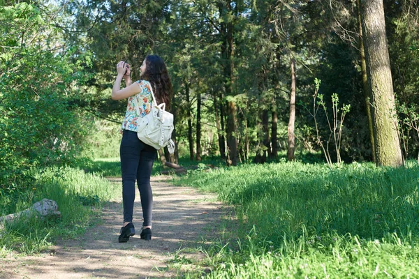 Chica con cámara tomando fotos de la naturaleza en primavera, hermoso bosque y árboles en un día soleado —  Fotos de Stock