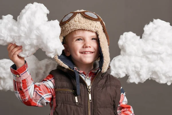 Αγόρι ντυμένος σαν ένα αεροπλάνο πιλοτικά στέκεται μεταξύ τα σύννεφα και τα όνειρα — Φωτογραφία Αρχείου