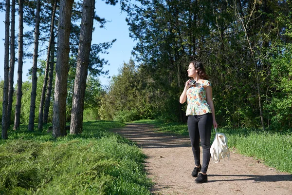 Chica caminando por un sendero forestal y tomando fotos de la naturaleza —  Fotos de Stock