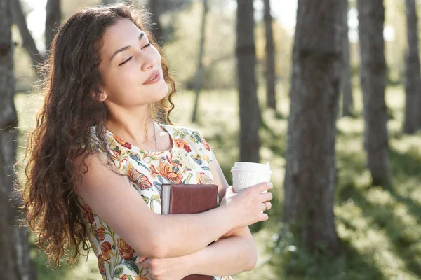 Menina bonita na floresta, luz solar brilhante ao redor, grama verde e árvores — Fotografia de Stock