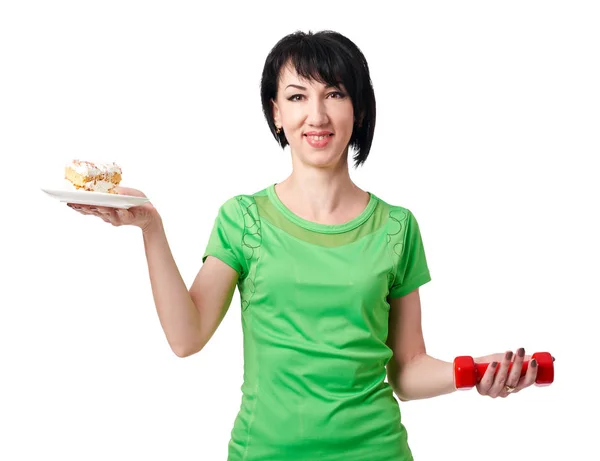 Girl choice between dumbbells and sweet cake, isolate on white background, sport and health concept — Stock Photo, Image