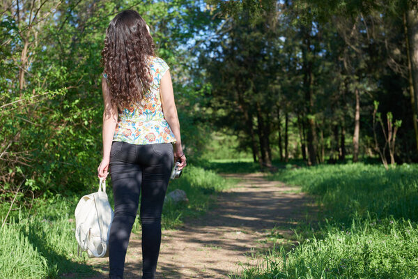 девушка ходит по лесной тропе и фотографирует природу

