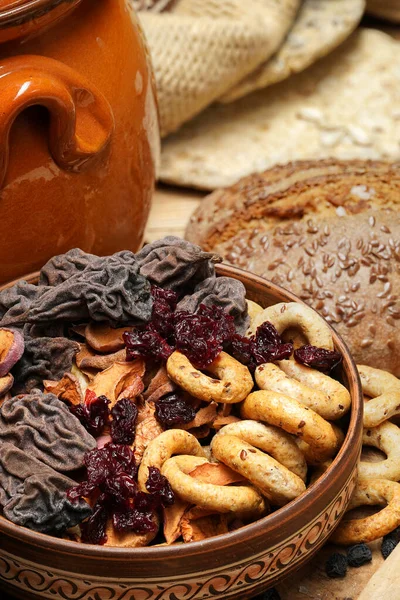 Pan fresco, rosquillas, frutas secas, semillas, sal, frasco y trigo en la madera - naturaleza muerta y concepto de alimentación saludable —  Fotos de Stock