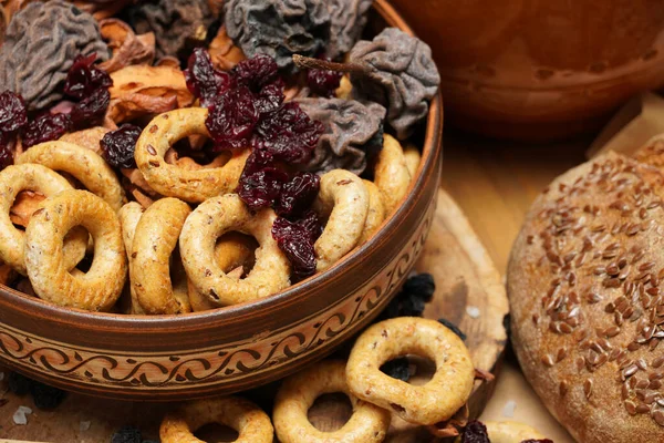木制上的新鲜面包、百吉饼、干果、种子、盐、罐子和小麦- -静止不动的生活和健康的饮食习惯 — 图库照片