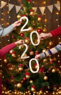 İnsanlar ahşap arka planda 2020 numara gösteriyor. Yeni yıl tatili konsepti.