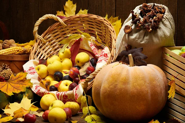 Фрукты и овощи с тыквами, яблоки, кукуруза, орехи, грибы, ягоды - осенний урожай и концепция здоровой пищи. Желтые листья. Натюрморт на деревянном фоне . — стоковое фото
