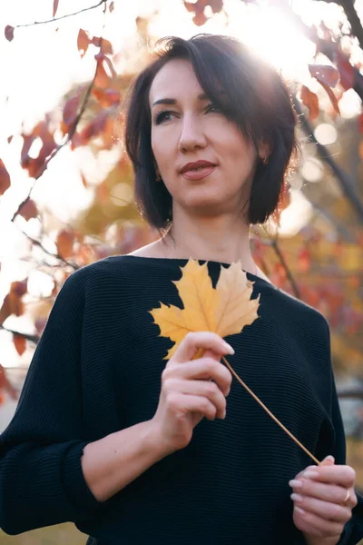 Mulher bonita e elegante de pé e posando em um parque da cidade no outono — Fotografia de Stock