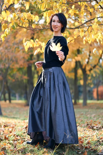 Mulher bonita e elegante de pé e posando em um parque da cidade no outono — Fotografia de Stock