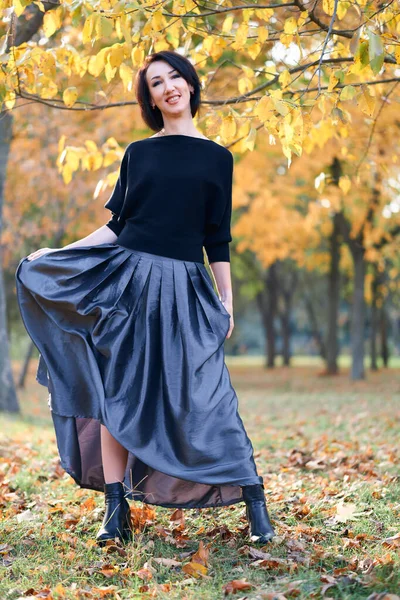 Mulher bonita e elegante de pé e posando em um parque da cidade no outono — Fotografia de Stock