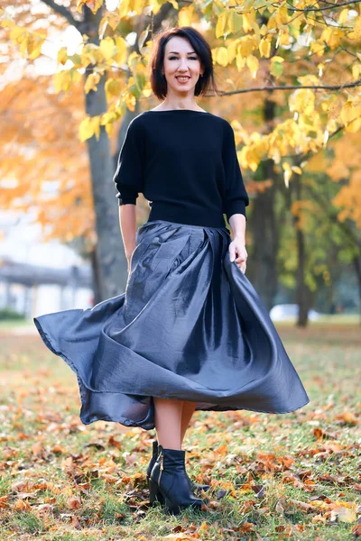 Mooie elegante vrouw staande en poseren in een stadspark in de herfst — Stockfoto