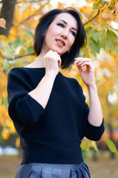 Mulher bonita e elegante de pé e posando em um parque da cidade no outono — Fotografia de Stock