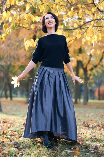 Mulher bonita e elegante de pé e posando em um parque da cidade no outono — Fotografia de Stock