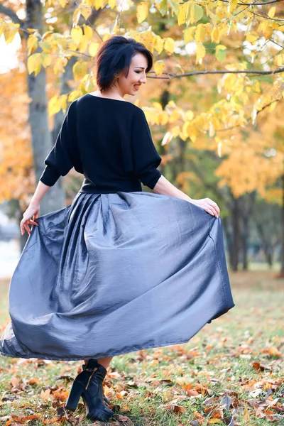 Krásná elegantní žena stojící a pózující v městském parku na podzim — Stock fotografie
