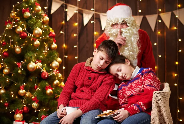 Діти довго чекали на Санту, тепер вони заснули і Санта спокійно йде на різдвяне дерево, щоб подарувати подарунки - Веселих свят і Веселих свят.! — стокове фото