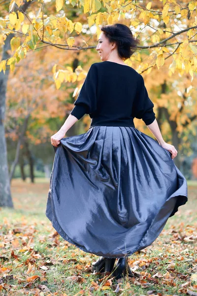 Krásná elegantní žena stojící a pózující v městském parku na podzim — Stock fotografie