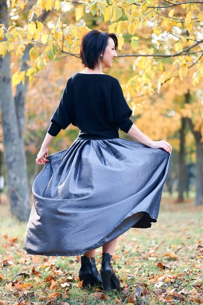 Mulher bonita e elegante de pé e posando em um parque da cidade no outono — Fotografia de Stock