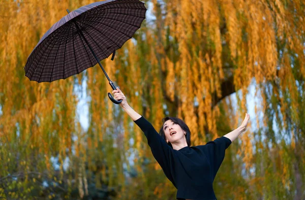 가을 도시 공원에서 우산을 펼치는 아름다운 여인 — 스톡 사진
