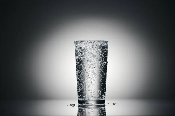 One glass of sparkling water on a dark background — Stock Photo, Image