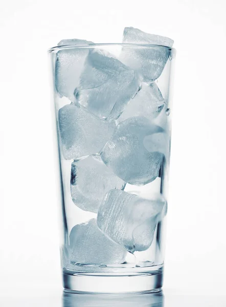 Один стакан воды, полный кубиков льда, белый фон, синий тонированный объект — стоковое фото