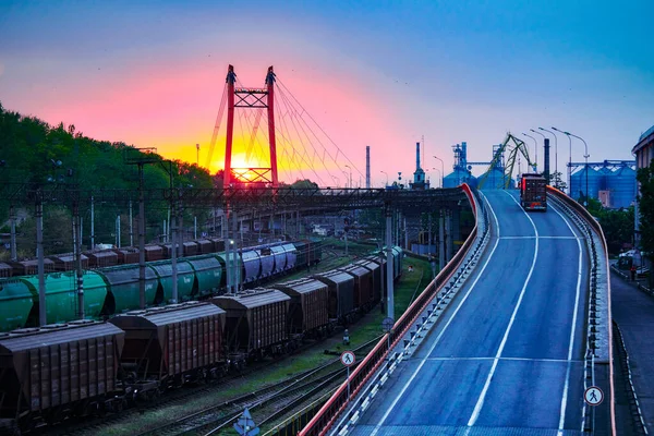 LKW mit Containerfahrten auf der Straße, Eisenbahnverkehr, Güterwagen im Industriehafen bei Sonnenuntergang — Stockfoto
