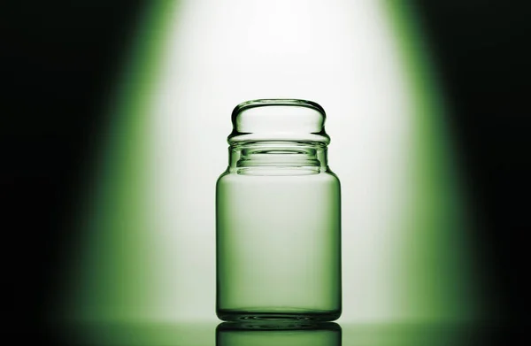 प्रकाश प्रभाव के साथ हरे, काले और सफेद पृष्ठभूमि पर खाली ग्लास जार — स्टॉक फ़ोटो, इमेज