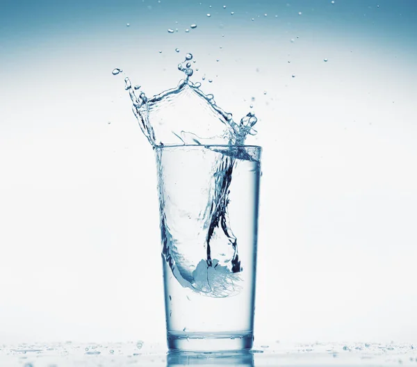 Egy pohár víz fröccsenő jégkocka, fehér háttér, elszigetelt tárgy — Stock Fotó