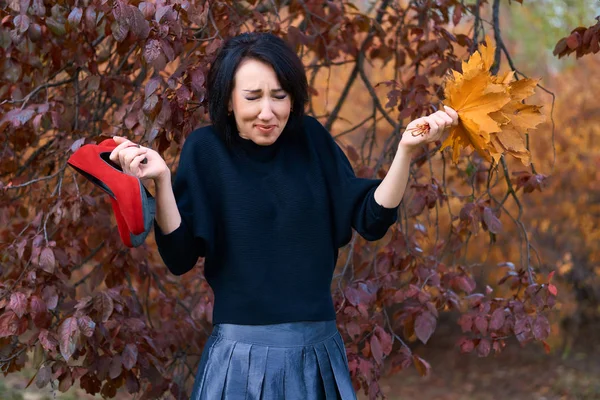 Krásná elegantní žena, která se baví a pózuje s kyticí žlutých listů a červených bot v podzimním městském parku — Stock fotografie