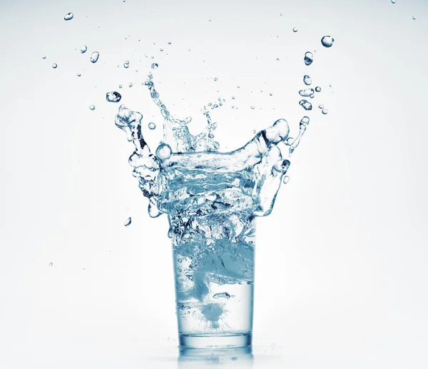 Egy pohár víz fröccsenő jégkocka, fehér háttér, elszigetelt tárgy — Stock Fotó