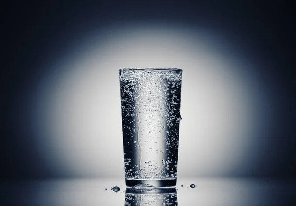 Одна склянка ігристої води на темно-синьому фоні — стокове фото