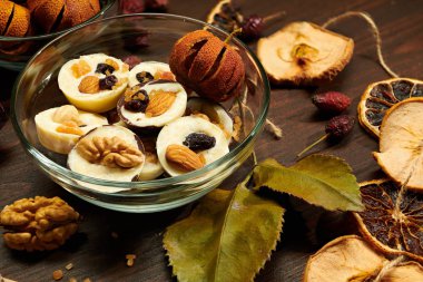 Kırsal masada ev yapımı çikolatalı şekerler, kuru meyve, gül çiçeği ve cevizle süslenmiş.